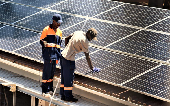 Des prestataires de services locaux installent des panneaux solaires sur les toits de l’Ambassade de Suisse à Harare.