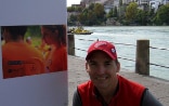 Curator Ashley Woods in front of the first panel of the photo exhibition “Making Peace” on the banks of the Rhine in Basel 