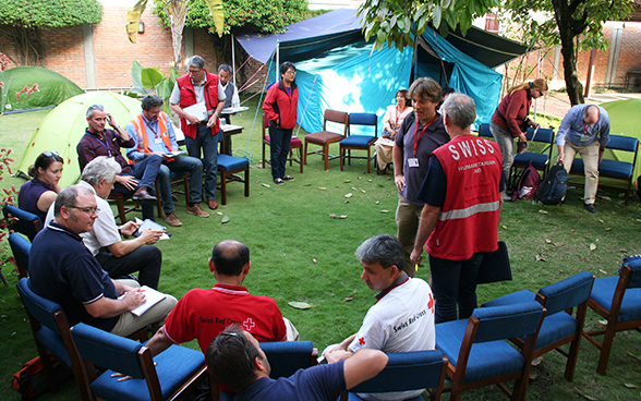 Das Soforteinsatzteam der Humanitären Hilfe des Bundes diskutiert mit Vertretern von NGO im Garten der Schweizer Botschaft in Nepal. 