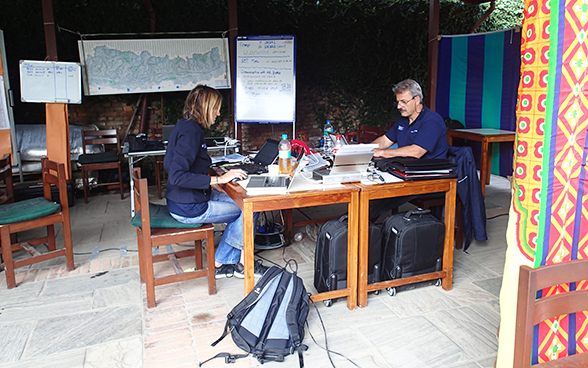 Zwei Mitglieder des Soforteinsatzteams der Humanitären Hilfe des Bundes arbeiten an einem Tisch.