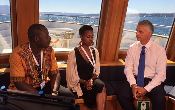 Le conseiller fédéral Didier Burkhalter échange avec  Ibrahim Koroma (à gauche) et Julienne Baroni, deux anciens enfants soldats, après le tournage d’un film,  lundi 23 août à Genève. 