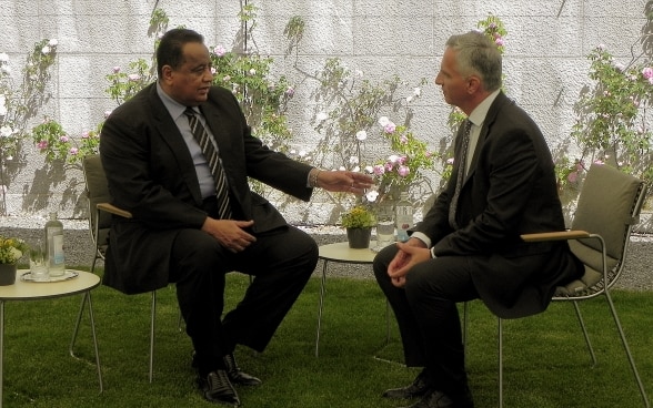 Didier Burkhalter and Ibrahim Ghandour, Sudanese Minister for Foreign Affairs, sitting and talking at table. 