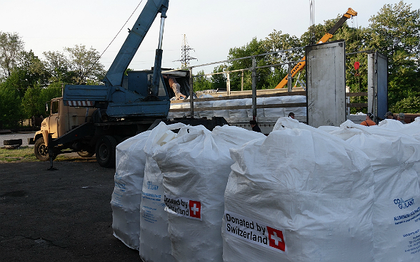 Die Hilfsgüter werden auf die Lastwagen des Hilfstransports verladen.