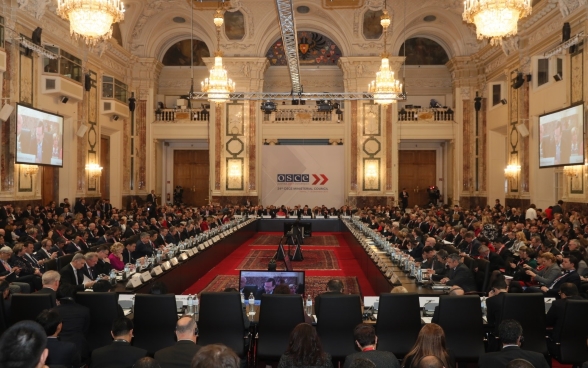 Die Minister der Mitgliedsstaaten der OSZE sind für die Konferenz in einem Saal versammelt.