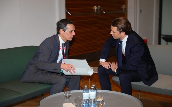 Bundesrat Ignazio Cassis sitzend im Gespräch mit dem österreichischen Aussenminister Sebastian Kurz.