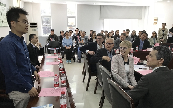 Dans une salle de classe de l’Académie des sciences de Xi’an, en Chine, un éudiant s’adresse au Conseiller fédéral Cassis