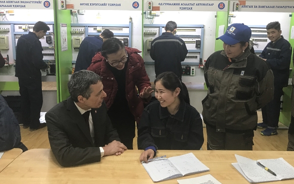 Federal Councillor Cassis in conversation with three Mongolian apprentices.