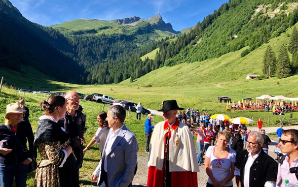 Ignazio Cassis discute con dei visitor dell’alpaggio.