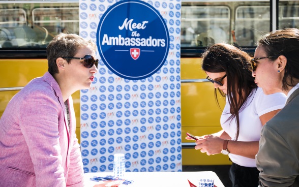 An ambassador talks to two visitors