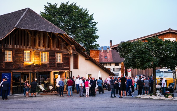 Des ambassadeurs et ambassadrices suisses discutent avec la population locale.