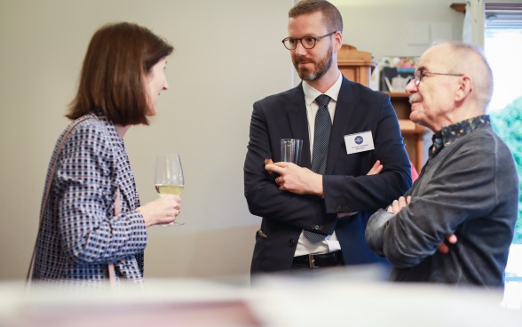 Two Swiss ambassadors talk to a member of the audience.