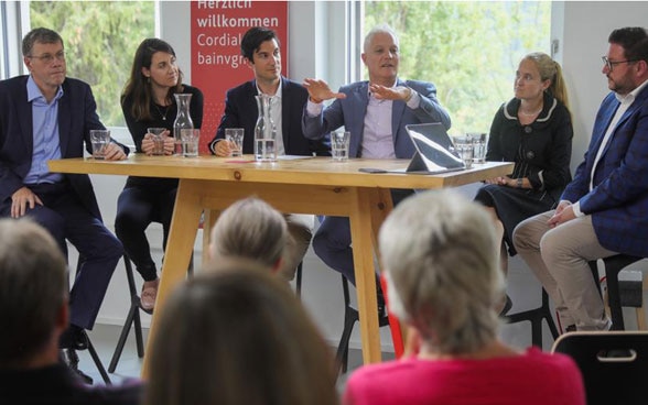 Swiss ambassadors are sitting around a table on their visit to the municipality of Scuol in the canton of Grisons and talk with the audience about Swiss foreign policy and their work.