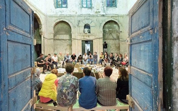 Festival «Dream City» in Tunis; eine Gruppe junger Menschen sitzt in einem Innenhof im Kreis.