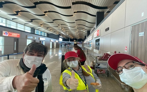 Thumbs up, Swiss caps and masks are a must for a photo pose at Dakar airport before the next flight to Switzerland.