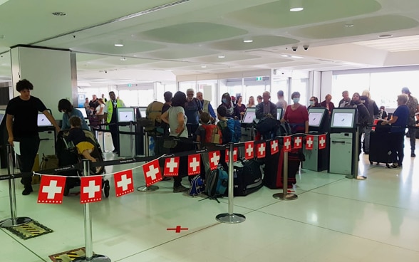 Nella sala del check-in dell'aeroporto di Sydney, una ghirlanda composta da piccole bandiere svizzere indica immediatamente dove si trova la fila corretta per il check-in. 