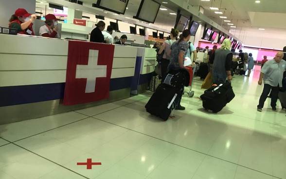 The square Swiss flag is displayed at a check-in counter at Sydney Airport. 