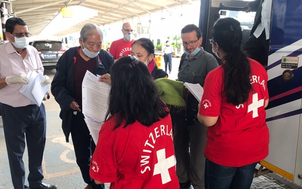 Des passagers descendent d’un bus à l’entrée de l’aéroport de Goa en Inde. Ils sont accueillis par du personnel des représentations suisses locales. 