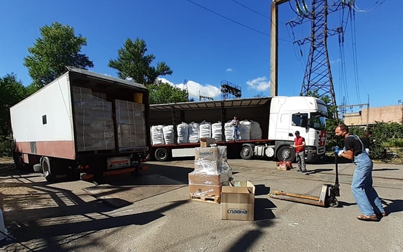  Swiss humanitarian aid logisticians load relief supplies into a truck.