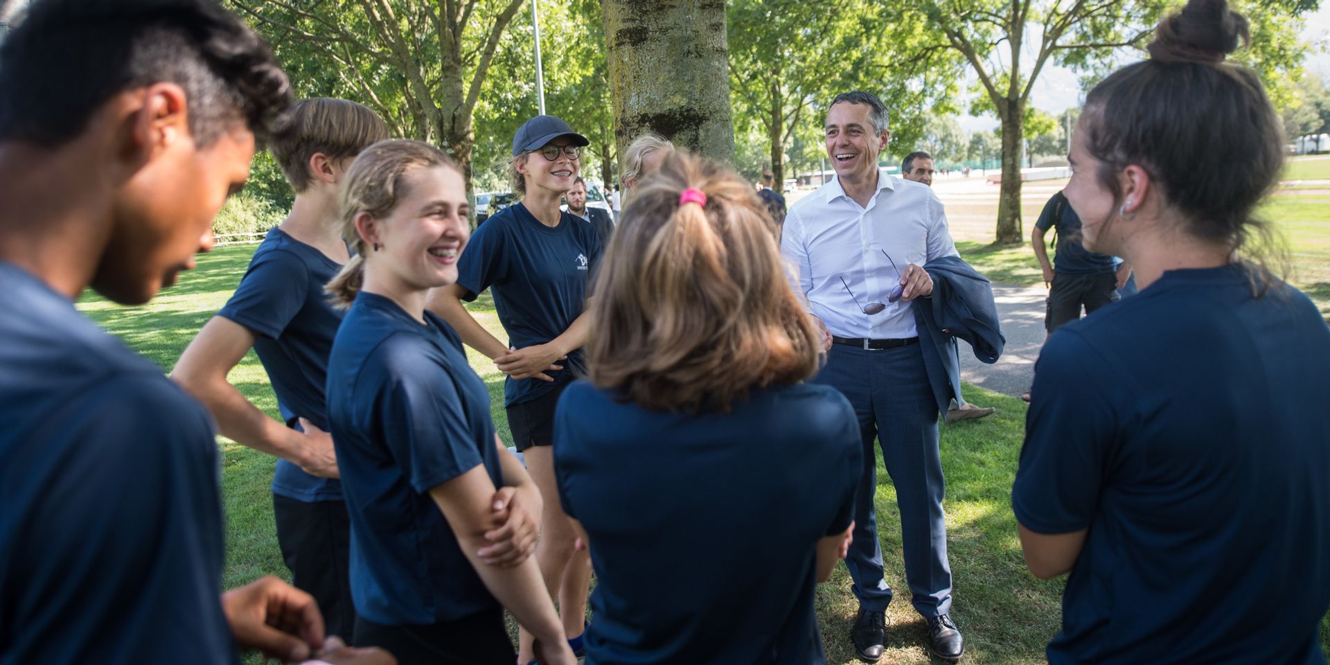 Federal Councillor Ignazio Cassis in conversation with track and field athletes during training. 