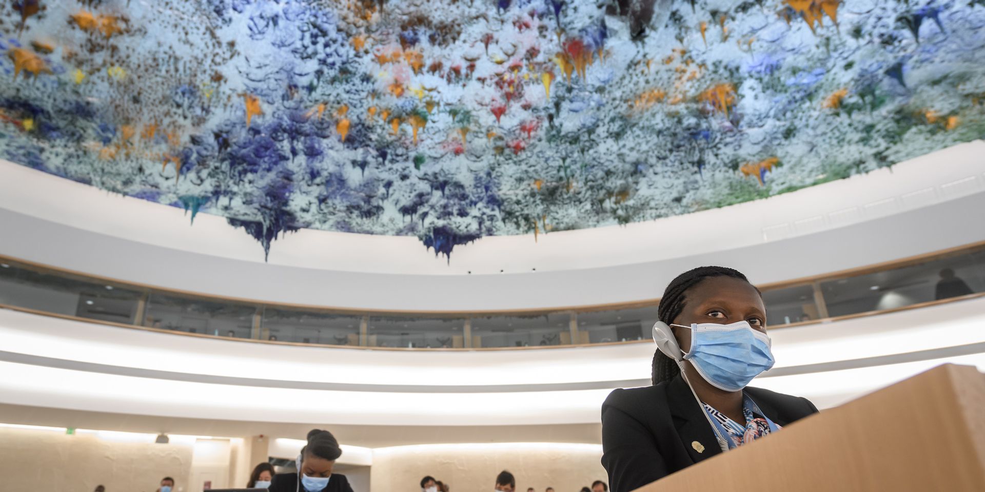  Une femme utilise un appareil de traduction pour écouter un orateur pendant la session du Conseil des droits de l'homme des Nations unies. 