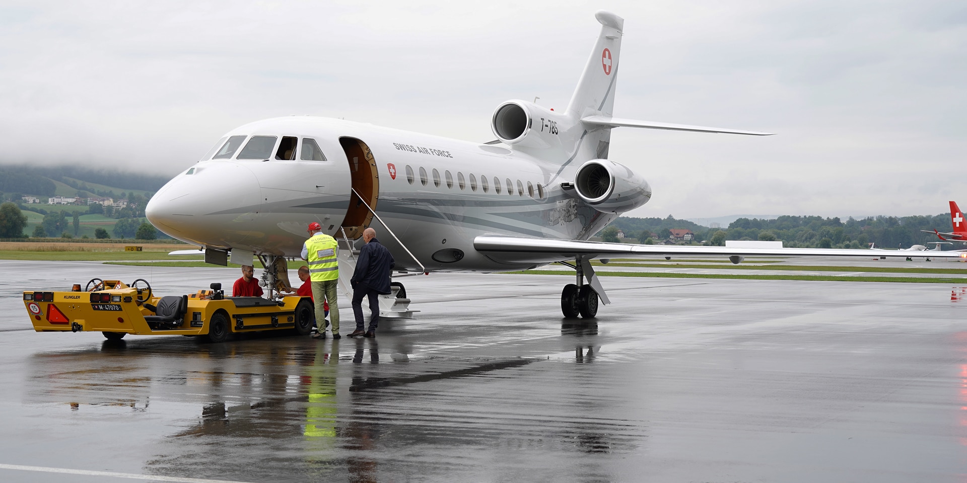 Deux hommes se tiennent devant un jet sur la piste de l’aéroport de Berne-Belp.