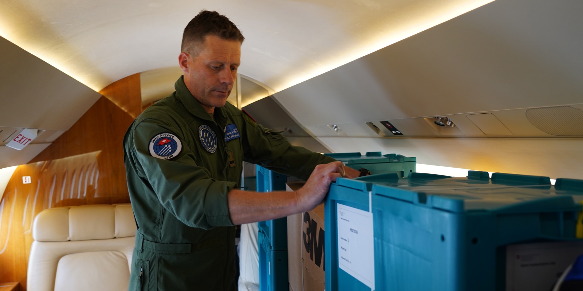 A pilot inside an aircraft checking that boxes of relief supplies are securely fastened. 
