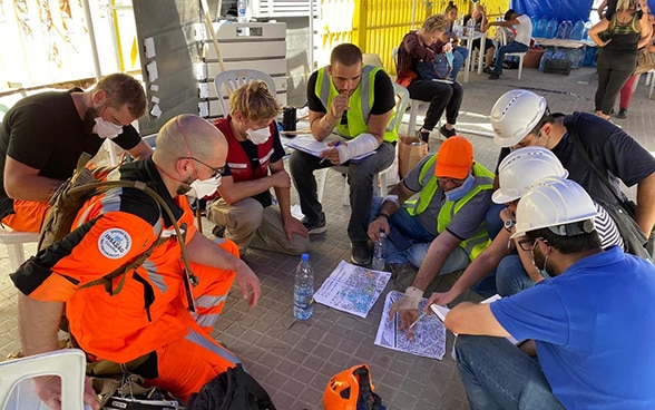 Experts from the Swiss Humanitarian Aid Unit discuss a map of the area.