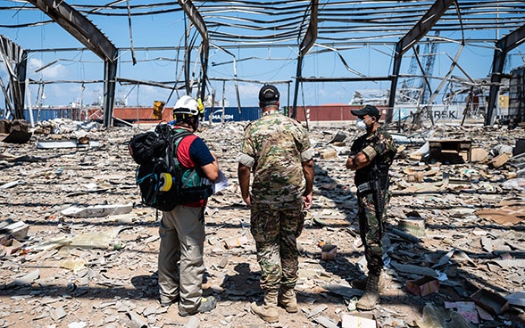 Ein Experte der Humanitären Hilfe des Bundes steht mitten in den Trümmern am Hafen von Beirut und unterhält sich mit den lokalen Behörden.  