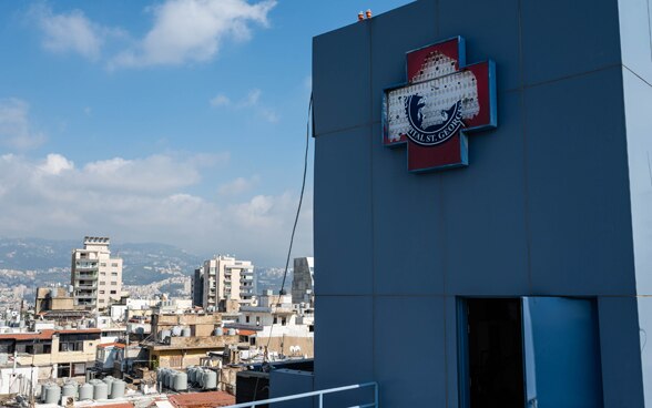 Vue de l'extérieur d'un hôpital en ruine. En arrière-plan, vous pouvez voir les conséquences de l'explosion sur la ville de Beyrouth.