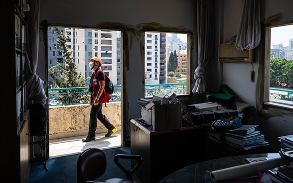 View from a demolished apartment without windows. Engineer Regina Wenk is walking on the balcony and looking at the damage.