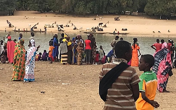  Alcune persone sostano ai bordi di un fiume