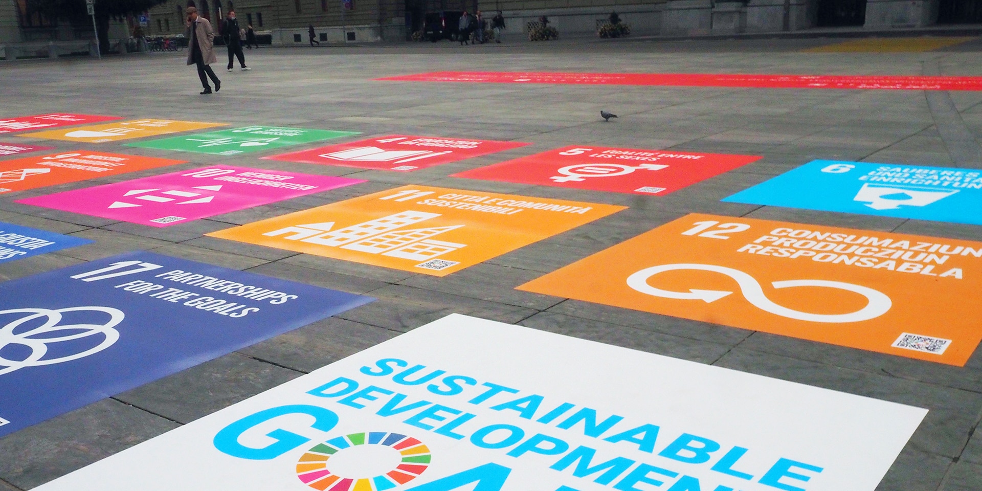Sul pavimento di Piazza federale sono incollati degli adesivi con i simboli dei 17 obiettivi di sviluppo sostenibile.