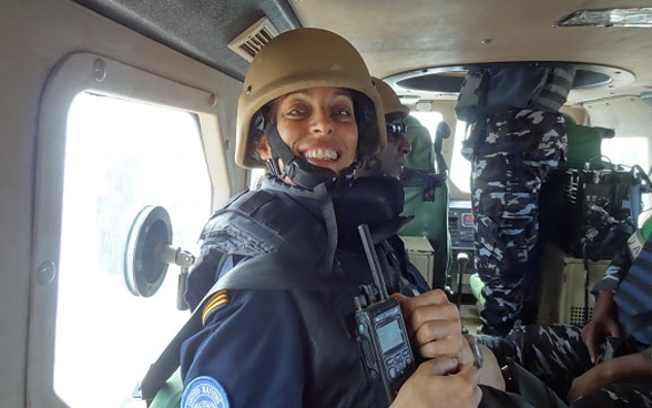  Eine Polizistin mit Helm und Walkie-Talkie sitzt in einem gepanzerten Fahrzeug.