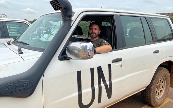  Un agente di polizia dell’ONU al volante di un’automobile bianca con la sigla «UN».
