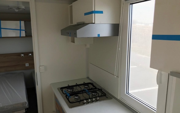The interior of a mobile living unit, with kitchen, bathroom and two bedrooms.
