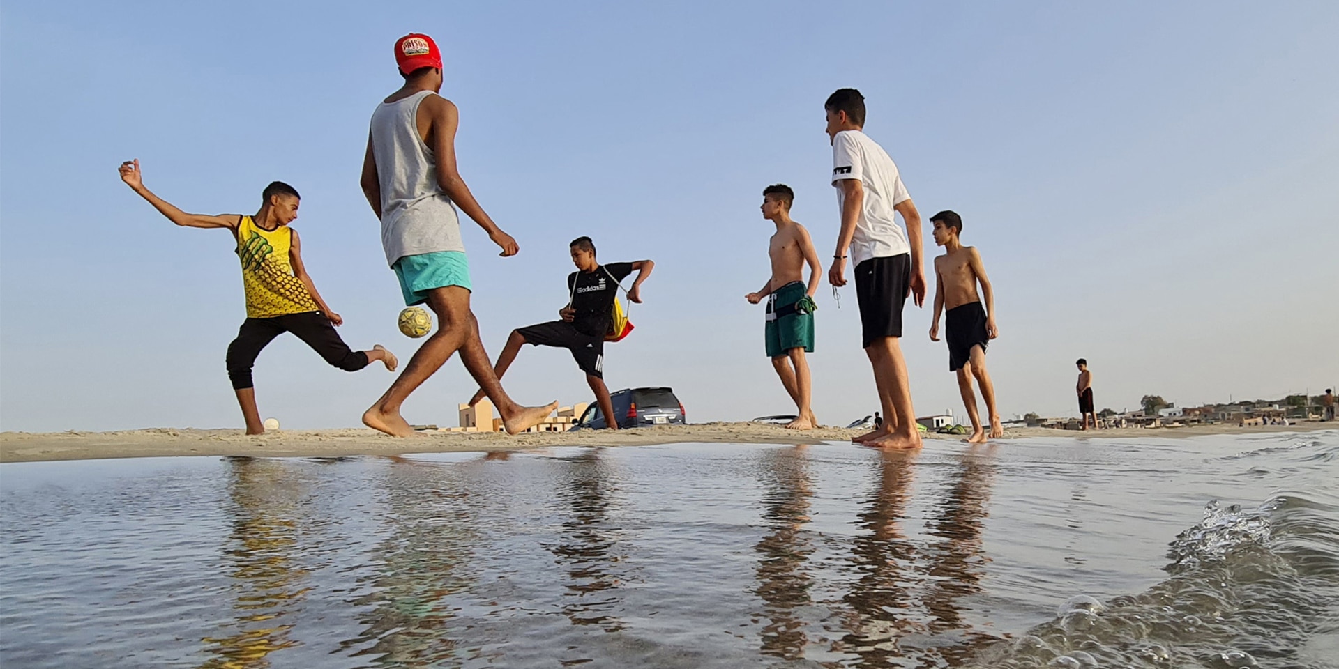Junge Leute spielen Fussball an einem Strand in der Stadt Garabulli, rund 70 km von der Hauptstadt Tripolis entfernt.