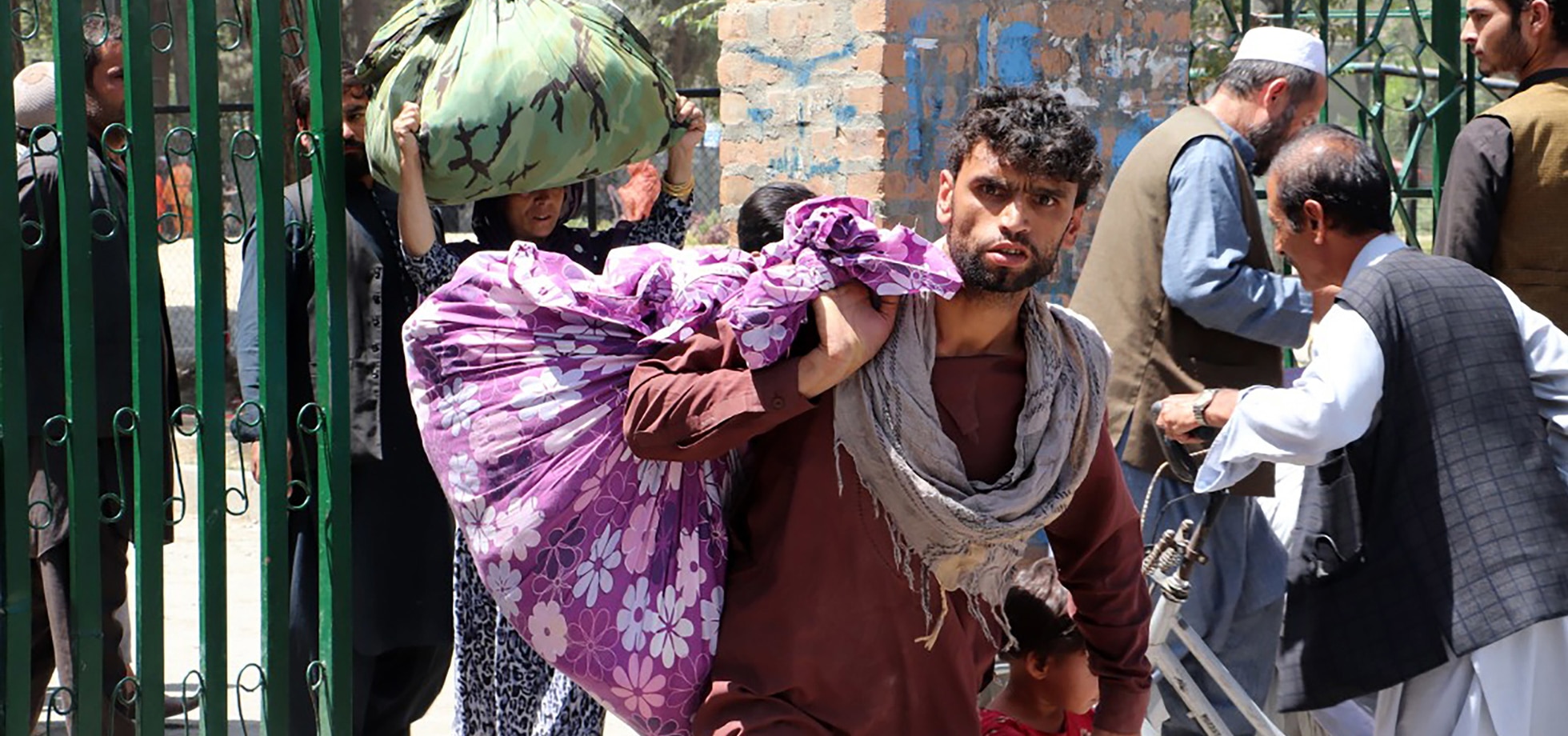 Ein Mann trägt in Kabul sein Hab und Gut in einem Laken über der Schulter.