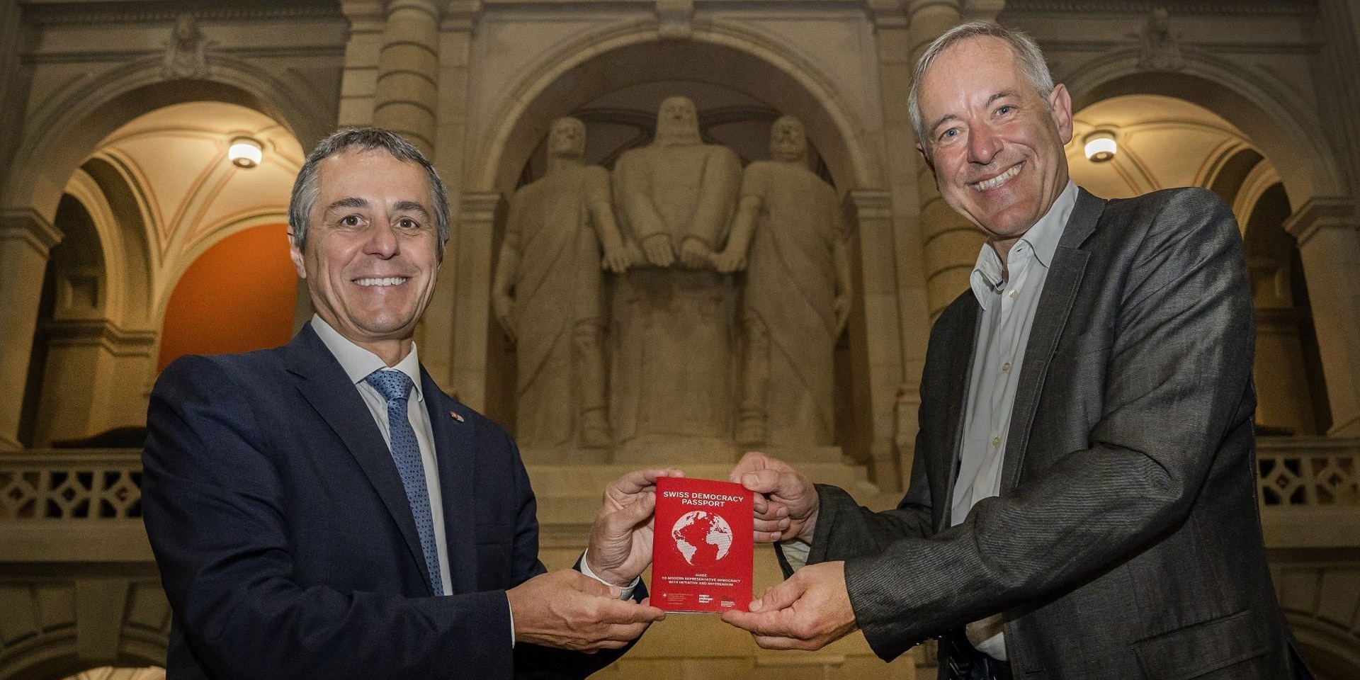 Bundesrat Ignazio Cassis und Bruno Kaufmann posieren mit dem Swiss Democracy Passport.