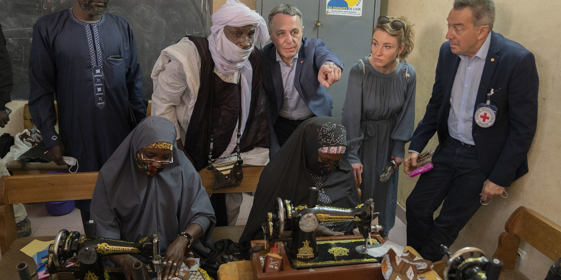 President Ignazio Cassis, National Council President Irène Kälin and ICRC President Peter Maurer watch tailors at work.