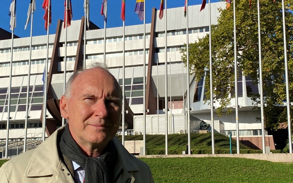 Porträt von Botschafter Christian Meuwly, im Hintergrund der Palais de l’Europe.