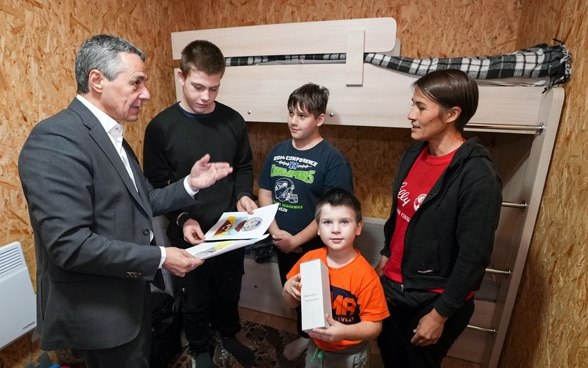 Bundespräsident Ignazio Cassis im Gespräch mit einer Familie, die von der Schweizer Unterstützung in der Ukraine profitiert hat.