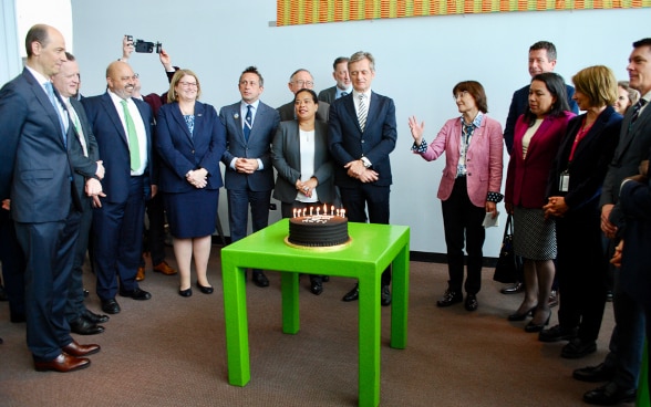 Representatives of the ACT group standing around a cake.