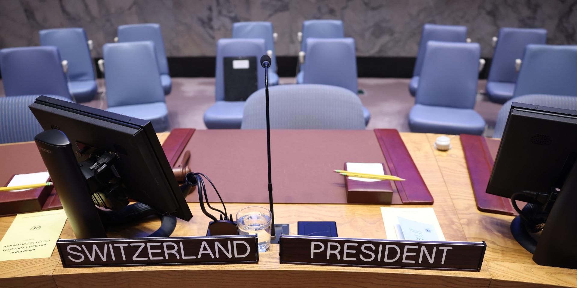 Deux panneaux boisés sont posés sur la table en bois du Conseil de sécurité de l'ONU. Sur l'un, est écrit "Switzerland" et sur l'autre "Président" (en anglais).