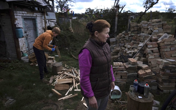 A Ukrainian boy chops wood in the garden.