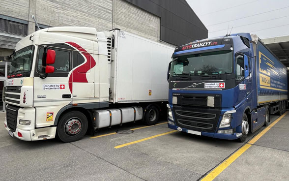 Un camion con la scritta "Donated by Switzerland".