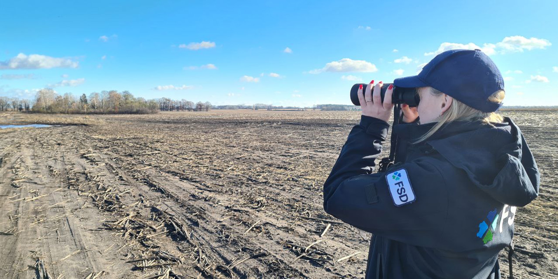 Ein FSD-Mitarbeiter führt eine nicht-technische Untersuchung durch und überwacht das Land mit einem Fernglas.