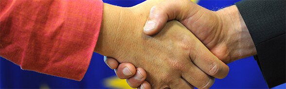 Image of a handshake with European flag in the background