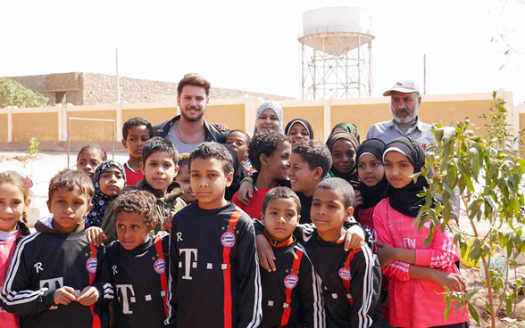 Bastian Baker pflanzt mit Kindern des Environmental Clubs in Nasseriya Bäume auf dem Pausenhof, Wasserprojekt Assuan. © DEZA