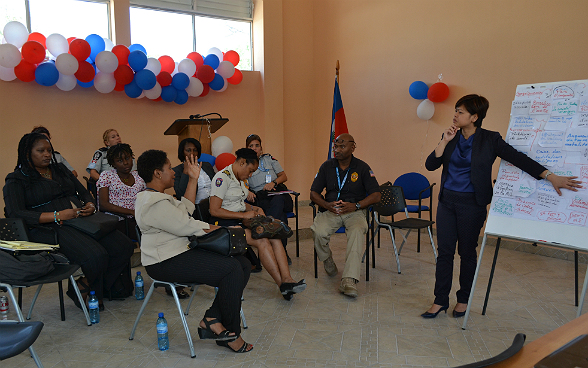 Eine Schweizerische Expertin in einem Klassenzimmer in Haiti und bei der Erläuterung eines Trainingskurses für zehn haitianische Polizisten im Rahmen eines Ausbildungsprogramms für die UN-Stabilisierungsmission in Haiti.