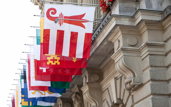 The flags of all of the Swiss cantons flying in front of the Federal Palace.